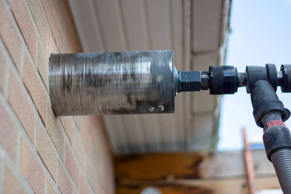 Aqua Protect boort gat in muur om ventilatie te installeren